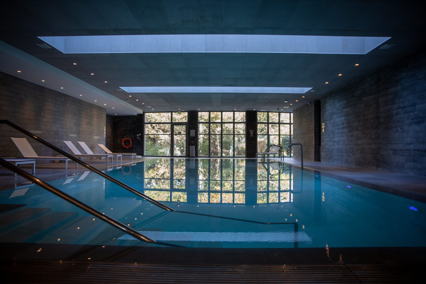 Piscine intérieure moderne avec transats blancs