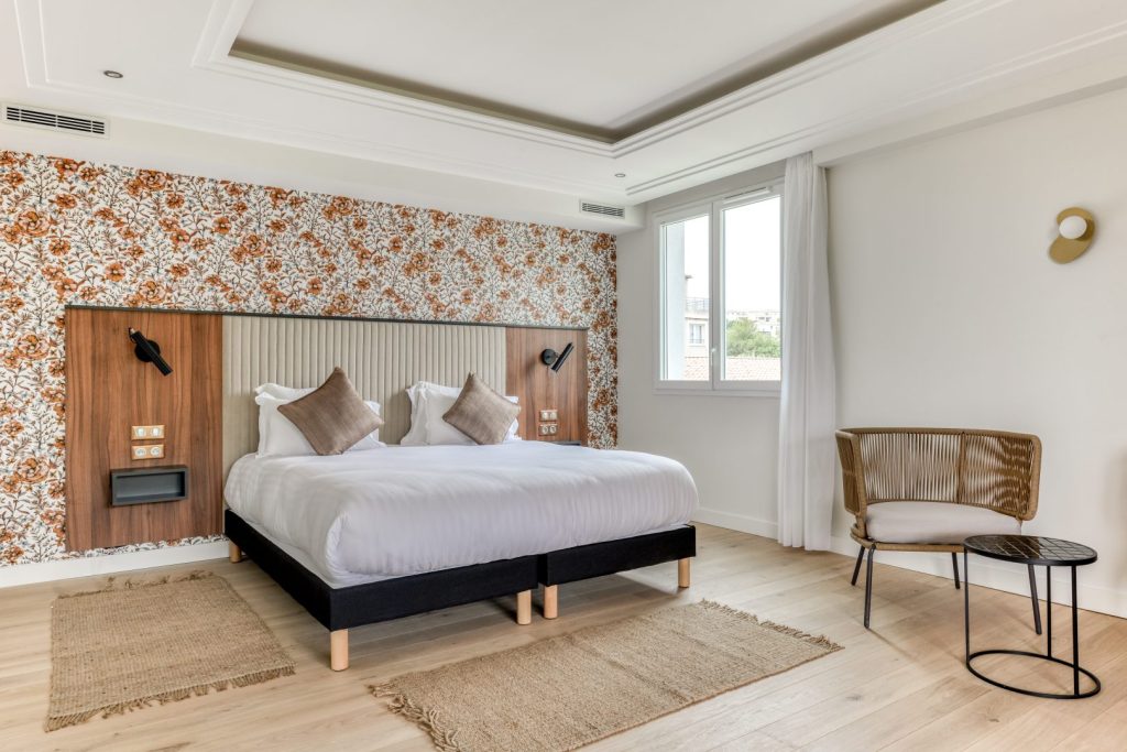 Chambre twin lumineuse avec deux lits simples et déco florale.