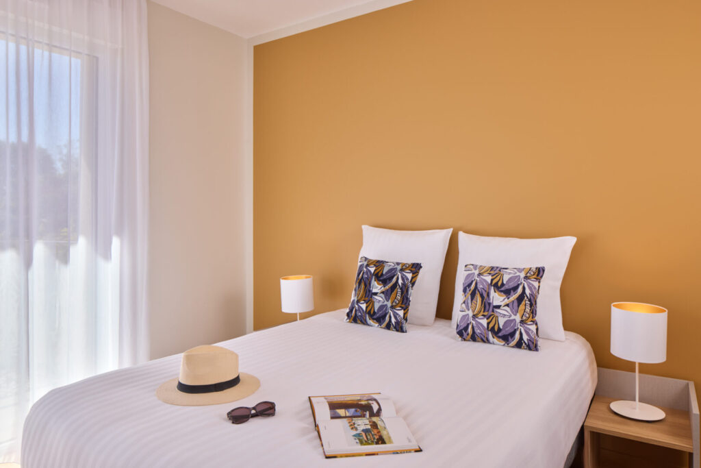 Chambre avec lit double et décoration chaleureuse au Zenitude Saint-Paul-lès-Dax