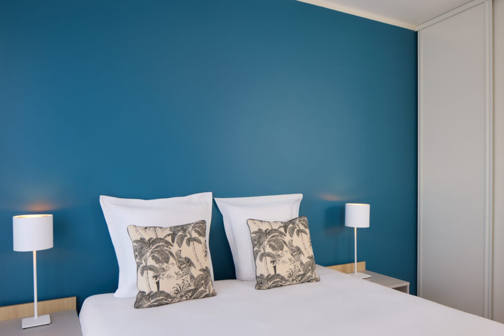 Chambre avec lit double et mur bleu au Zenitude Hôtel-Résidences Bordeaux St Jean