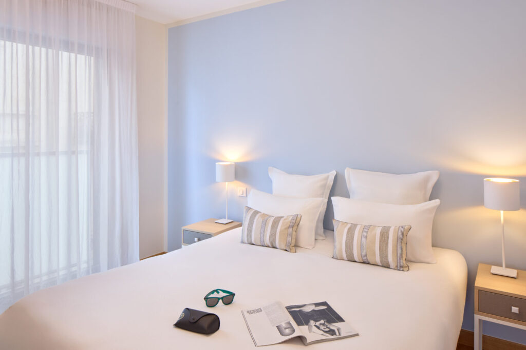Studio élégant avec lit double, décoration moderne et vue sur l’extérieur.