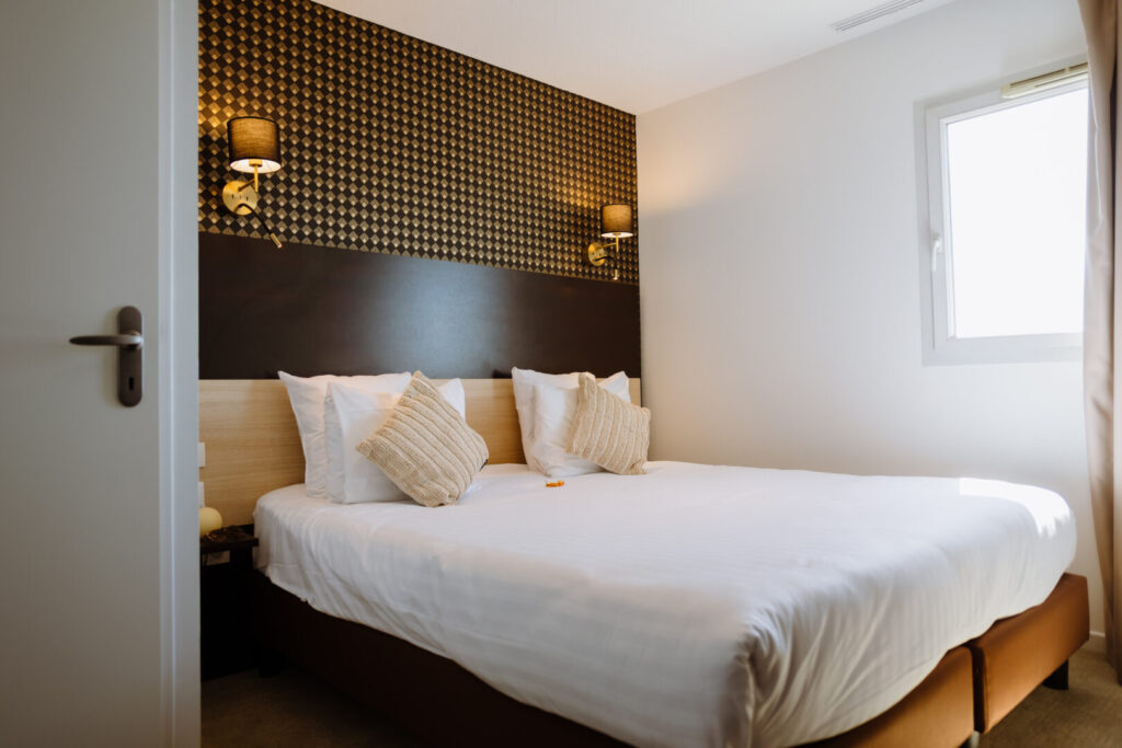 Chambre avec lit double et tête de lit décorative