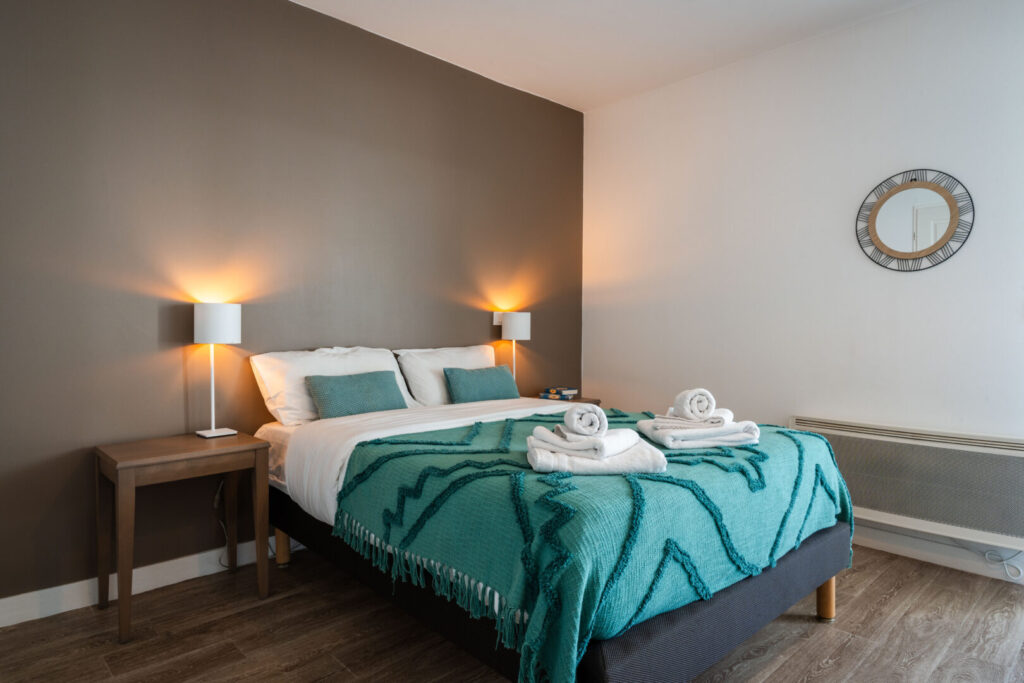 Chambre avec lit double et mur taupe au Zenitude Hôtel-Résidences Clermont Ferrand Stadium