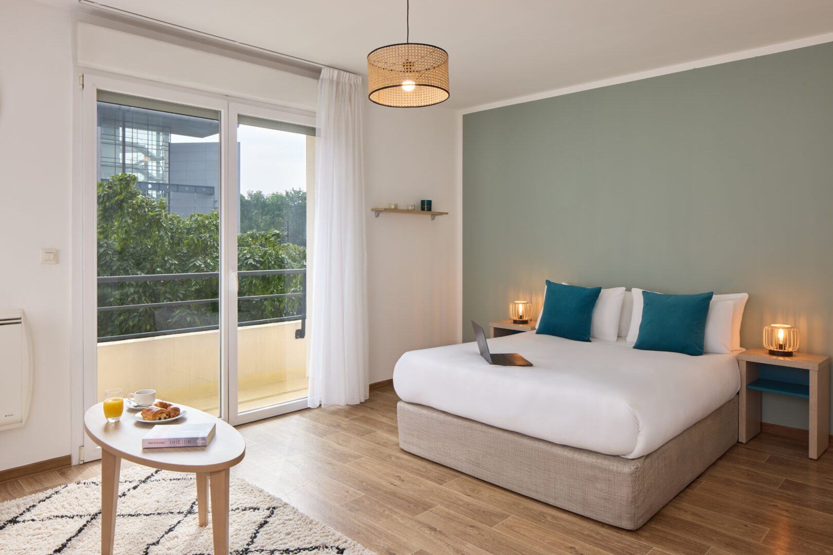 Chambre lumineuse avec lit double et porte-fenêtre donnant sur l'extérieur.