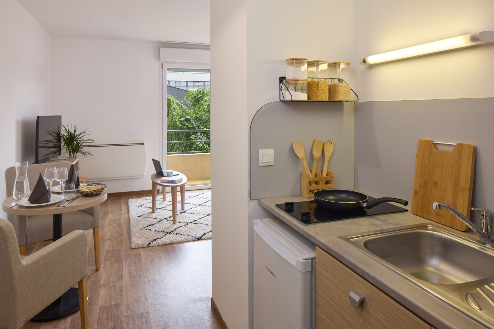 Kitchenette équipée avec plaques de cuisson et évier dans l'appartement.