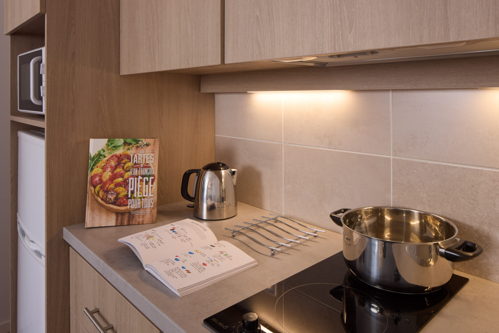 Cuisine moderne équipée avec livres de recettes et accessoires.