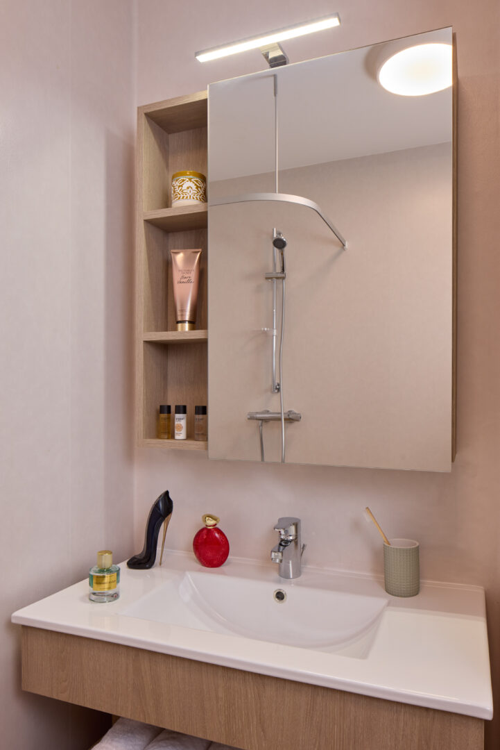Salle de bain moderne avec douche à l’italienne et mobilier bois clair.