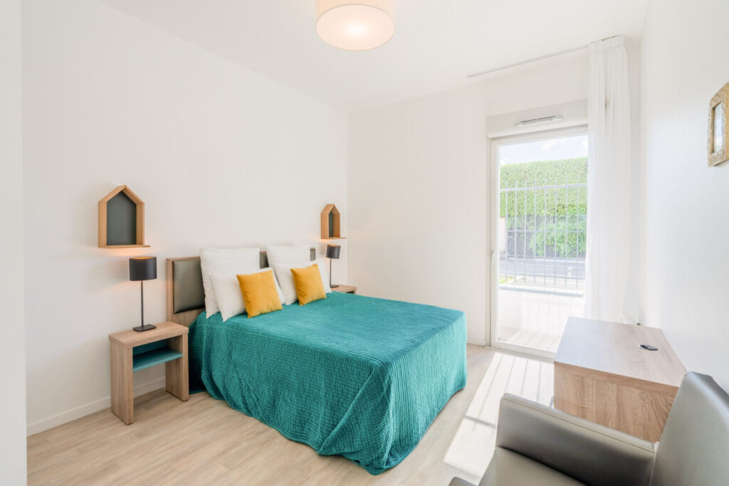 Chambre double lumineuse avec couvre-lit turquoise