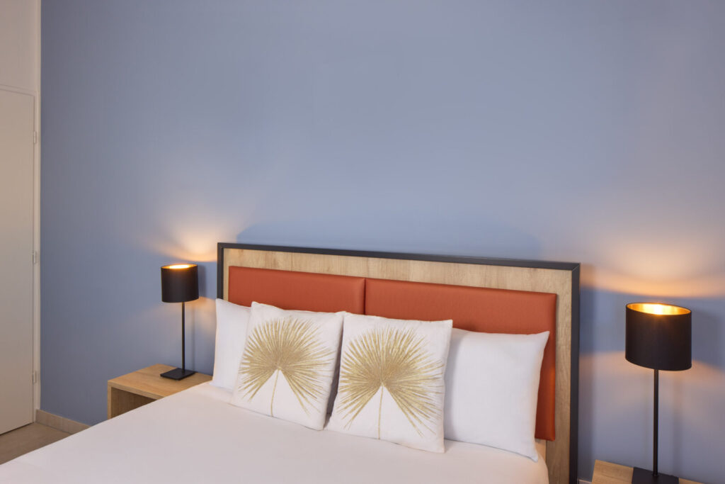 Chambre double avec tête de lit orange et table de chevet