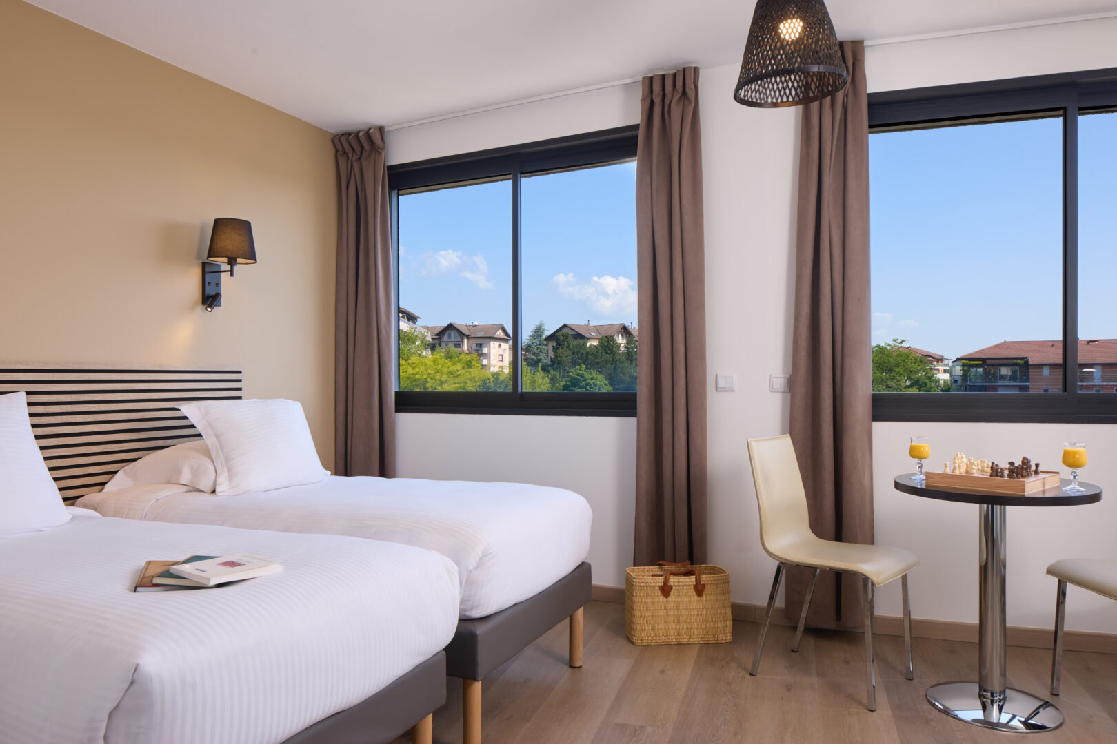 Chambre twin lumineuse avec deux lits simples et grande fenêtre au Zenitude Ferney-Voltaire