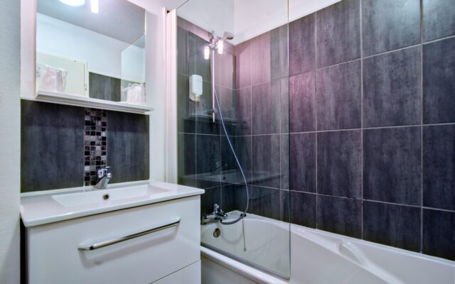 Salle de bain moderne Zenitude Hôtel-Résidences Bordeaux - Aéroport avec baignoire et carrelage gris
