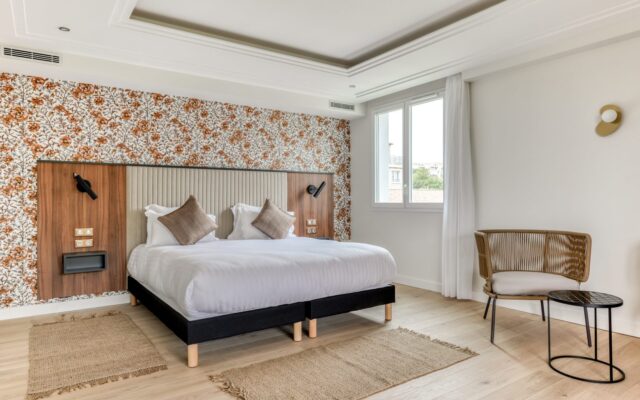 Chambre twin lumineuse avec deux lits simples et déco florale.