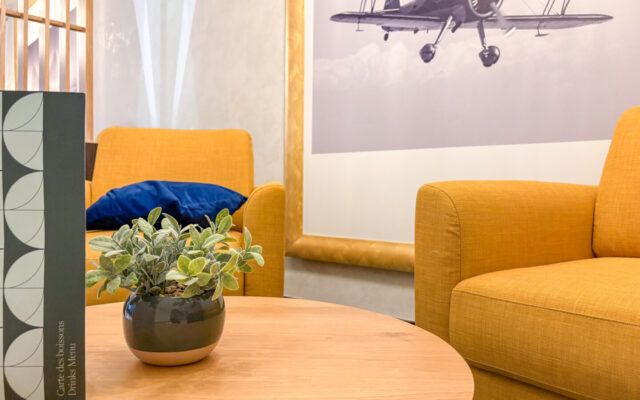 Canapé cosy avec table basse et verre pour un moment détente.