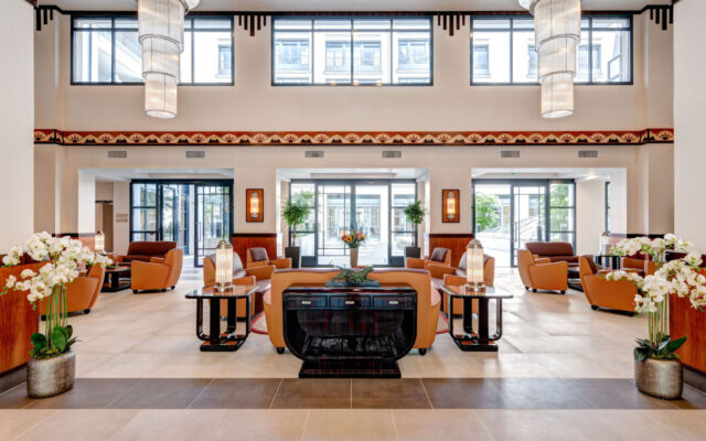 Lobby spacieux et lumineux avec fauteuils en cuir et décoration élégante.