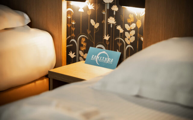 Chambre double avec lits confortables et éclairage chaleureux.