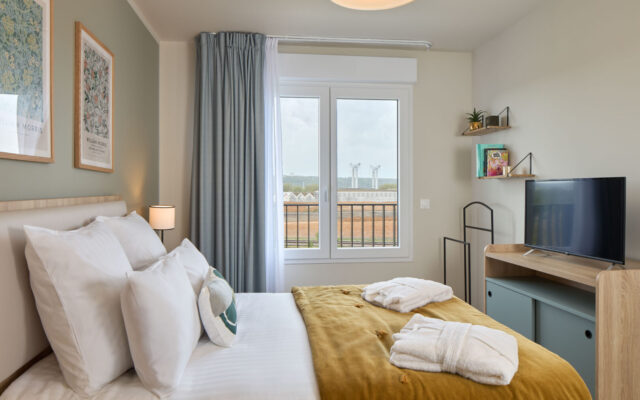 Chambre avec lit double, décoration élégante et vue sur l'extérieur.